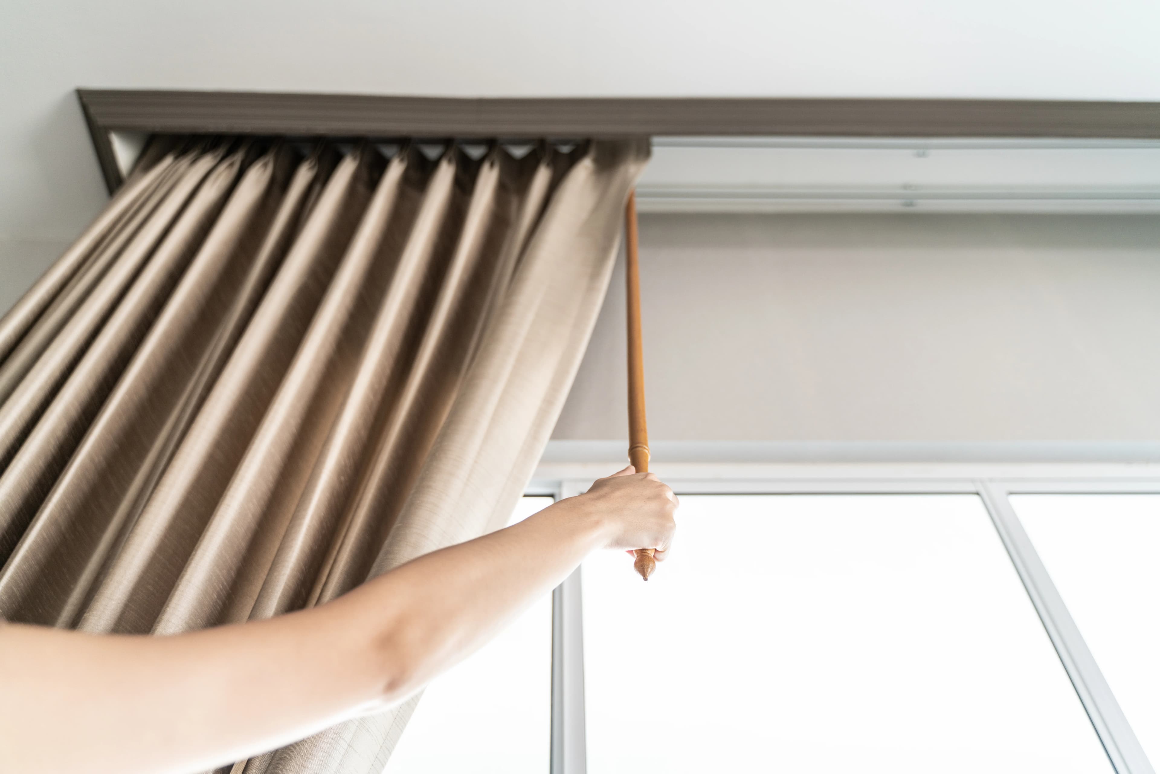 Close-up of ripple fold curtain track with neatly pleated fabric curtains